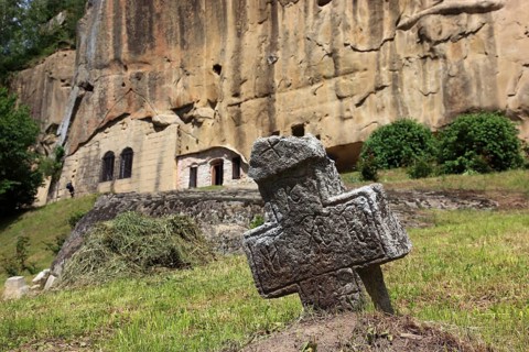 Corbii de Piatra rock monastery, stone ravens carved into a massive, 30-meter high sandstone wall,