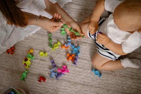 A colorful scene of a mother and child playing with vibrant toys, exuding joy and connection