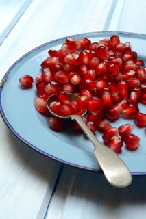 Pomegranate seeds and spoons on plate, Punica granatum