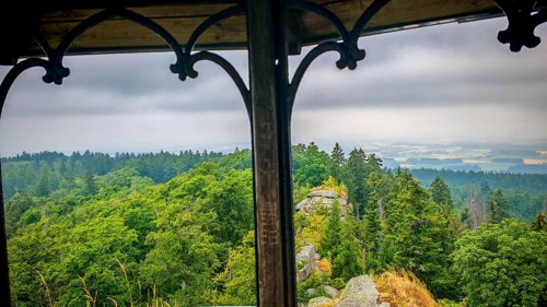 View from a viewpoint, Großer Waldstein, over a dense green forest with cloudy sky, Fichtelgebirge