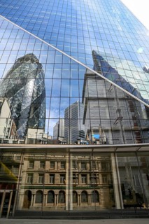 Reflection of skyscrapers in a glass façade, including The Gherkin, nicknamed one of London's most