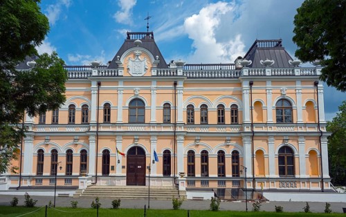 A historic building with an elaborate façade and several flags on the front, Manuc Bey Castle,