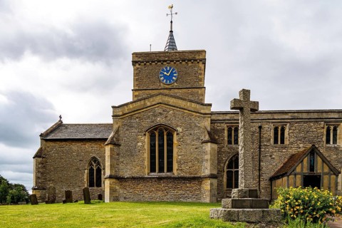 Medieval church tower of St James the Great with stone memorial cross in foreground, Bierton,
