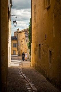A couple strolling through the old town alleys of Saint Emilion, France