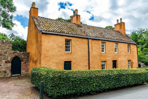 College Hill House, once the Old Rosslyn Inn, stands behind a hedge in Roslin village, Midlothian,