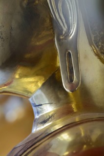 The photo shows a section of the left earlobe of a gilded Buddha statue, the gilding shows fine