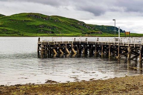 Timber pilings of the wooden pier reaches into the Kyles of Bute at Tighnabruaich, Argyll,