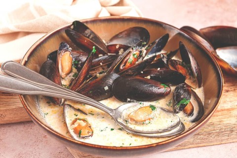 Mussels in creamy garlic sauce, served with fresh herbs and spices, homemade, no people