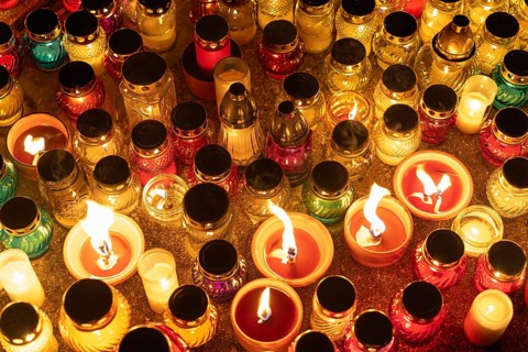 Colorful candle jars glowing warmly in the night. A huge number of multicolored burning candles and