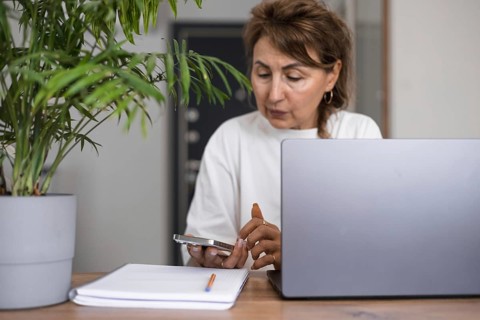 Portrait serious pensive mature business woman in white clothes thinking or making decision, using