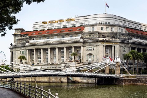 The neoclassical Fullerton Hotel and Cavenagh Bridge beside the Singapore River and its footbridge,