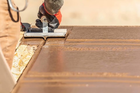 Construction Worker Using Hand Groover On Wet Cement Forming Coping Around New Pool