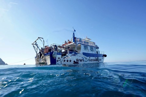 Big boat, diving boat at sea under blue sky, diver on board, Cap de Creus marine reserve dive site,