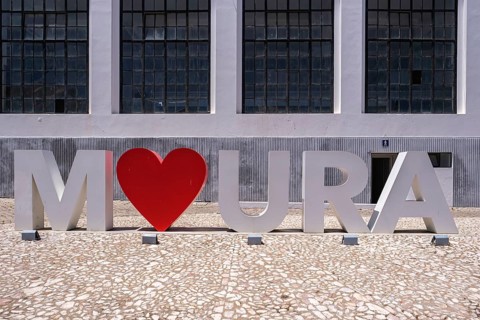 Large modern lettering with a heart in front of a building with a large window front, Moura, Beja,