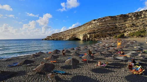 Neolithic caves, former hippie paradise, beach with umbrellas and sun beds by the sea, quiet