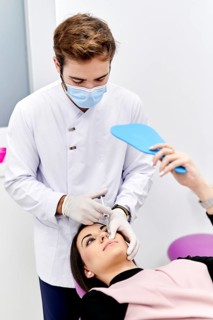 A medical professional in a white coat and sterile gloves administers a hyaluronic acid injection