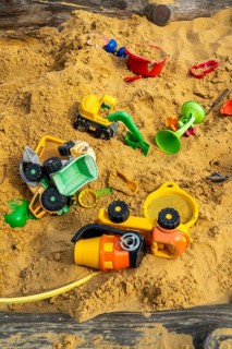 Sandpit, on a children's playground, sandpit with various plastic toys, excavator, shovels, moulds