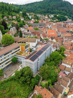 City view with solar roof and surrounding houses and vegetation, new PV system at