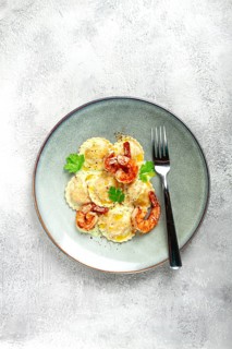 Ravioli with shrimp, in cream sauce, with spices and herbs, top view, no people