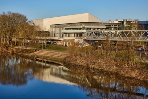 Congresshalle Saarbrücken, river Saar, stairs, footbridge, trees, bushes, blue cloudless sky,