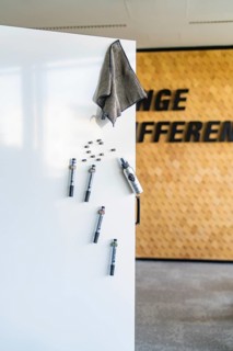 White surface with magnets and a towel in front of a wooden paneling