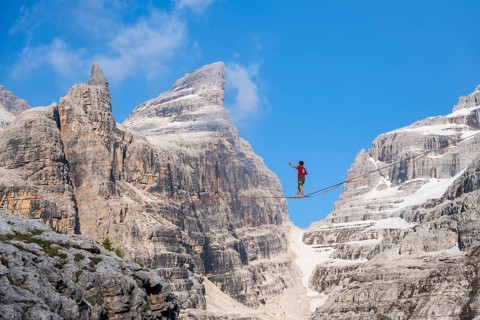 Slackliner in the mountains, mountain peaks of the Brenta Mountains, at Refugio Francis Fox