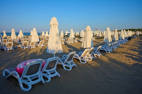 Empty sandy beach with set up white sun loungers and umbrellas, Evrenseki, Manavgat, Antalya,