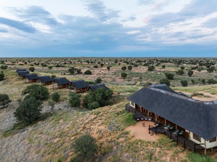 The Ta Shebube Rooiputs Lodge in the Kalahari Desert during the rainy season with green vegetation.