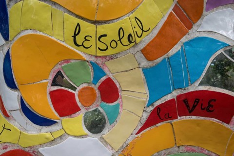 Part of a colorful sculpture with the inscription le Soleil and la vie, Giardino dei Tarocchi or
