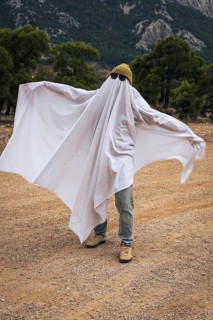 Creative homemade ghost costume for Halloween celebration outdoors. Simple family activity,