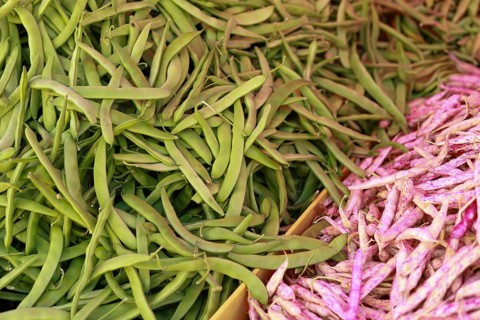 Mixed beans with green and pink pods, illustrating a contrast in color and texture at a market