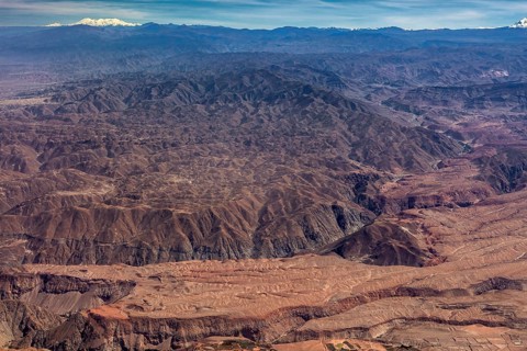 Vast, rocky mountainous area with deep canyons and reddish hues, the landscape and desert near