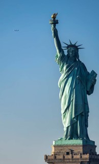 Majestic view of the Statue of Liberty standing tall in New York against a serene blue sky