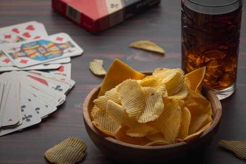 Chips and playing cards with a drink on a table