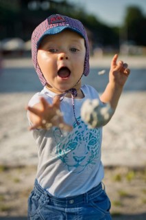 A two year old boy throwing a sand ball in Wroclaw, Poland