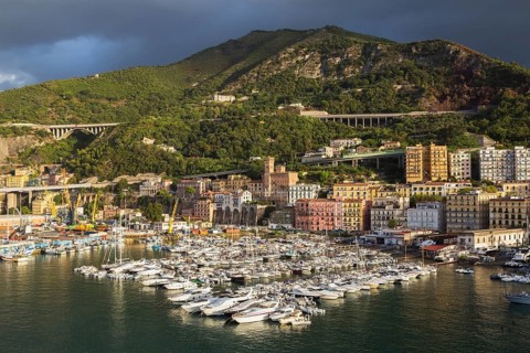 High angle view of marina with luxurious private yachts and sailboats bordered by apartment