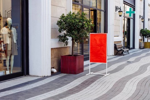Mockup, retail storefront features bright red sign placed on clean street. Large windows showcase