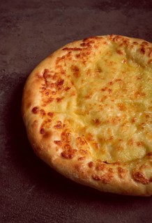 Khachapuri in Megrelian, a traditional Georgian dish, flatbread with cheese, top view, no people