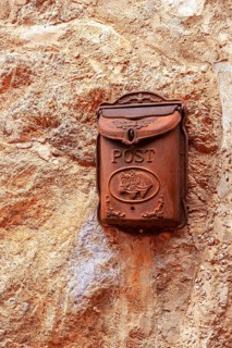 Rust-colored mailbox on a house façade in the picturesque mountain village of Valdemossa, Majorca,