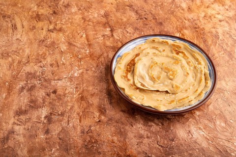 Stack of Plain Fried pancakes on brown concrete background. side view, copy space