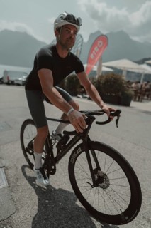 Young man riding a racing bike on Lake Garda. Sunny weather and dolce vita