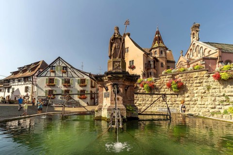 Fountain Fontaine de Saint-Léon and St Leo's Chapel in Eguisheim, Alsace, France
