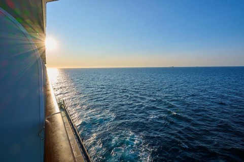 View from cruise ship, Mein Schiff 6, onto the wide sea at sunrise, under a clear blue sky, autumn,