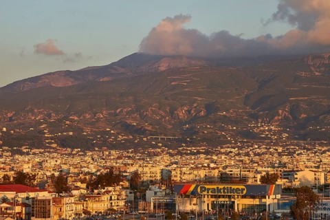 City panorama with mountains and a commercial building in the foreground in the evening light,