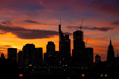 The silhouette of Frankfurt's banking skyline stands out against the luminous evening sky in the
