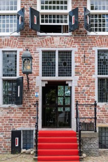 Main entrance of a historic building with red carpet and symmetrical windows, Coevorden, province