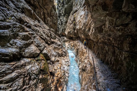 Hiker in a gorge, Hammersbach flows through Höllentalklamm, near Garmisch-Partenkirchen,