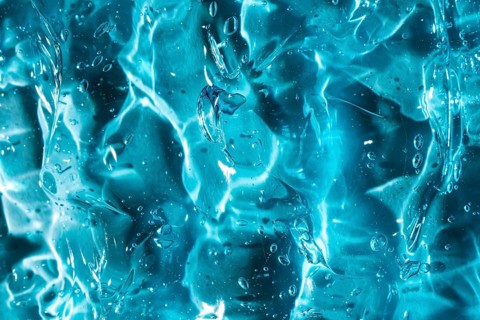 Close-up of vibrant blue gel texture, showcasing smooth, glossy surfaces and encapsulated bubbles.