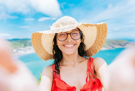 Beautiful tourist girl taking a selfie on the beach. Happy tourist girl taking a selfie on the