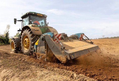 John Deere 8R 340 tractor engaged in field work operating an Agri-World FTC series soil tiller,